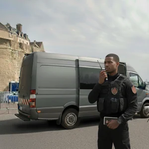 Agent de sécurité événementielle en communication radio devant un PC Sécurité Mobile (camion) pour la gestion d'un événement en Ille-et-Vilaine. Services de Gardiennage Sigmaxis.