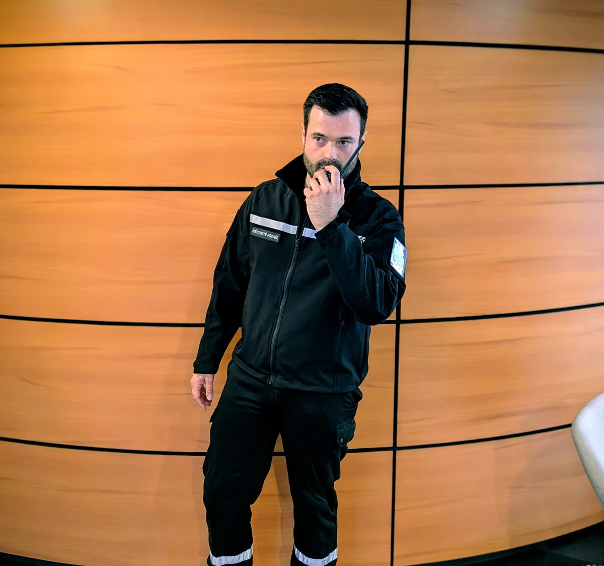 Agent de sécurité privée en tenue réglementaire communiquant à la radio, compétence opérationnelle du MAC APS