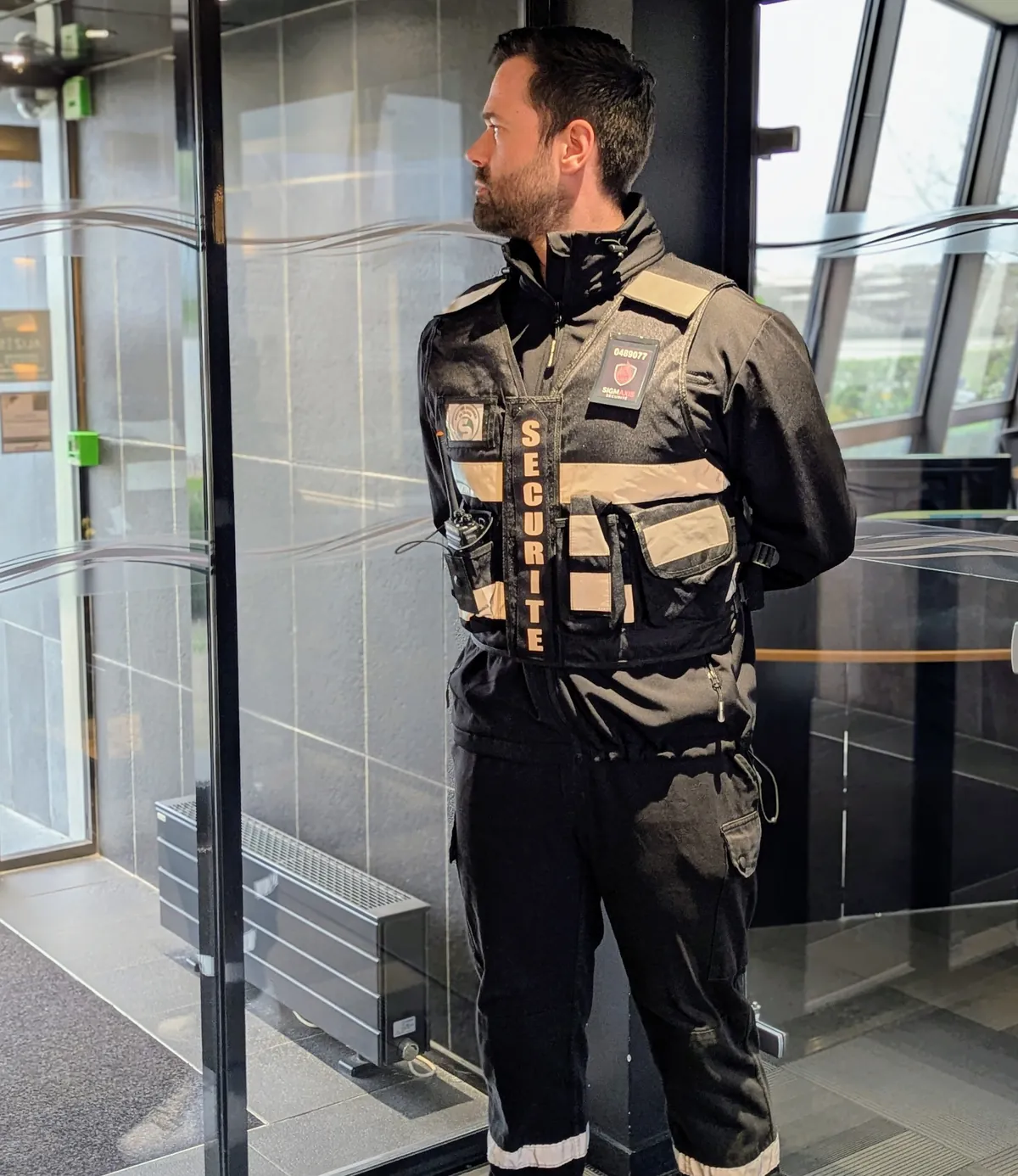 Agent de sécurité Sigmaxis en gilet d'intervention assurant le contrôle d'accès d'un établissement à Rennes
