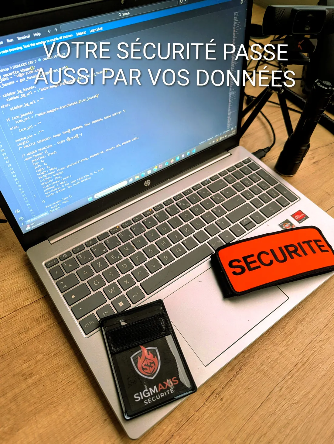 Poste de travail du bureau d'études Sigmaxis : développement de l'ERP interne, brassard sécurité et carte professionnelle. La conformité passe aussi par des données hébergées en France.