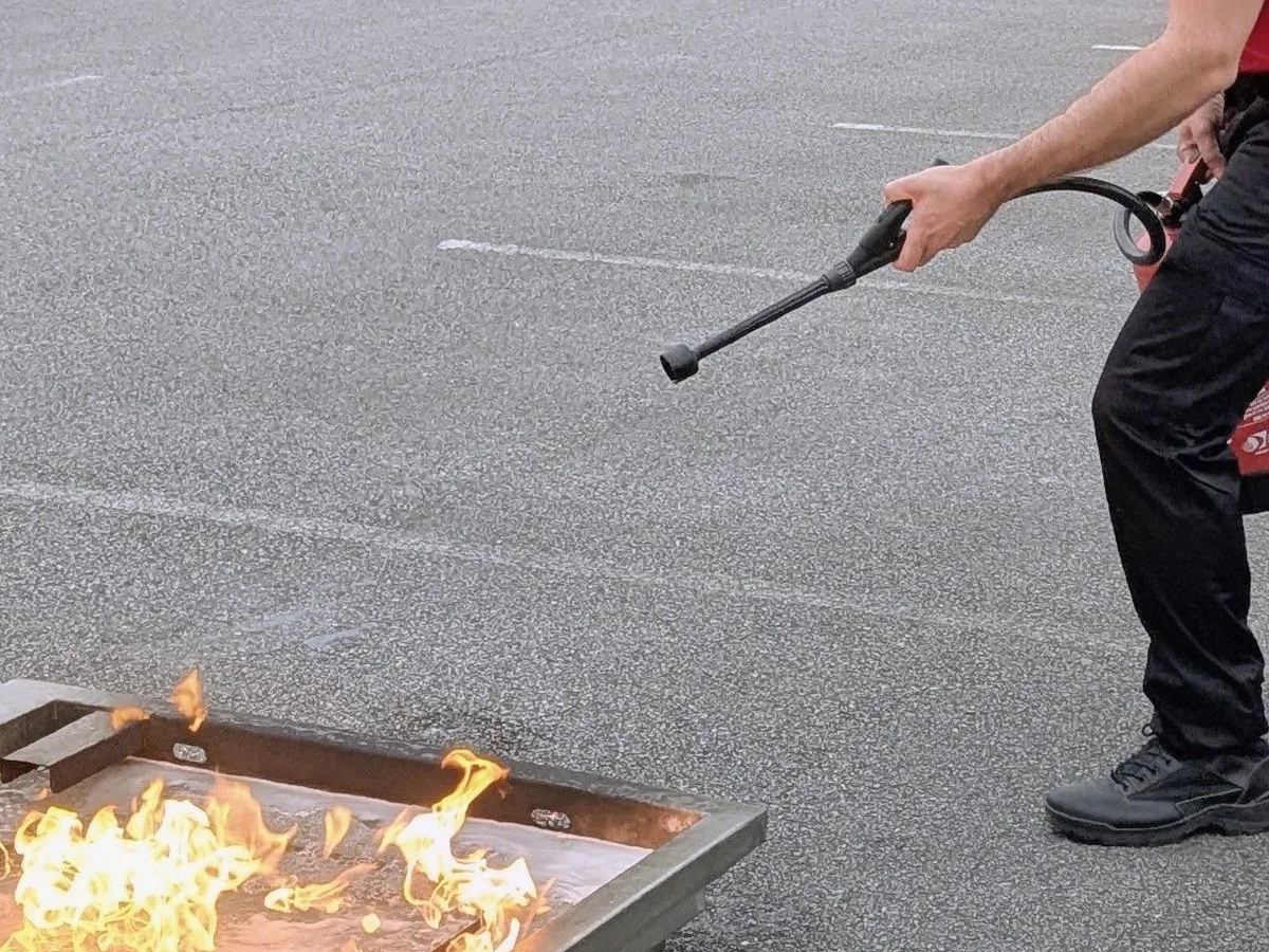 Formateur Sigmaxis manipulant un extincteur sur feu réel lors d'un exercice au Centre d'Affaires Alizés à Cesson-Sévigné